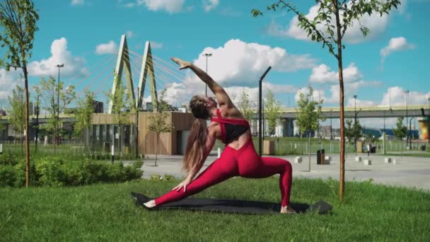 Kırmızı Eşofmanlı Yetişkin Bir Kadın Köprünün Yanındaki Parkta Egzersiz Yapıyor — Stok video