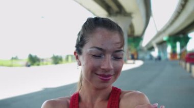 Köprünün altında eli ile poz veren gülümseyen yetişkin bir kadın. Orta çekim