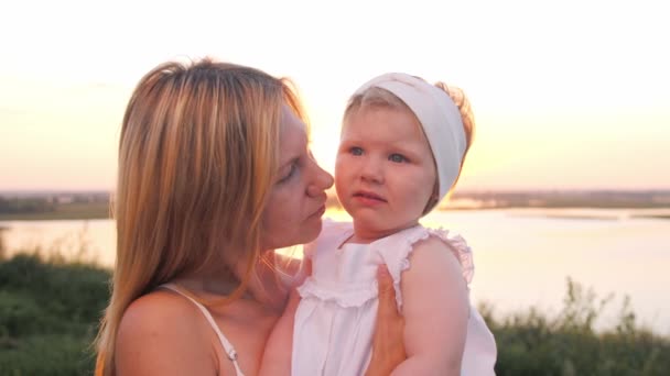 Una Mujer Sostiene Pequeña Hija Sus Brazos Atardecer Habla Con — Vídeo de stock