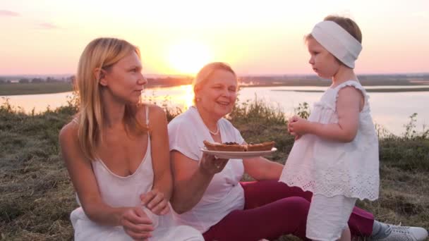 一个只有女性成员的家庭 日落时坐在山上野餐 吃着浆果派 — 图库视频影像