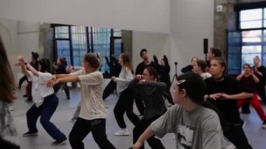 08-08-2022 RUSSIA, KAZAN: büyük ayna stüdyosunda farklı yaşlarda dans eden erkekler ve kadınlar senkronize olarak dans ediyorlar. Orta çekim