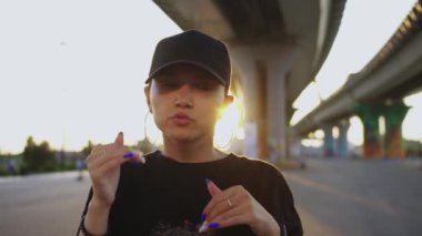 Köprünün altında dans eden ve kameraya bakan genç bir kadın. Portre