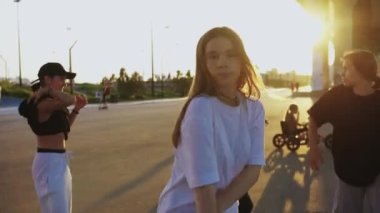 Gün batımında köprünün altında dans eden dört genç kadın. Orta çekim