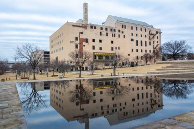 Oklahoma City, Oklahoma, United States of America - January 18, 2017. Exterior view of the Oklahoma City National Memorial Museum in Oklahoma City, OK, with reflection in the Reflecting Pool. clipart
