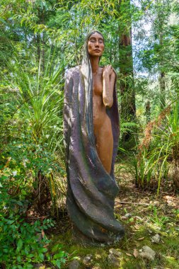 Marysville, Victoria, Avustralya - 24 Mart 2017. Marysville 'deki Bruno Ark Heykel Bahçesi' nde bitki örtüsü arasında güzel bir kadın heykeli..