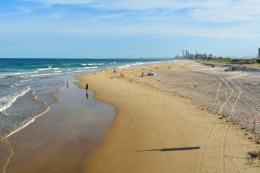 Main Beach, Gold Coast, Queensland, Avustralya - 10 Ocak 2018. Spit 'te kumsal, uzaktaki Sörfçüler Cenneti' nin insanları ve gökdelenleri..
