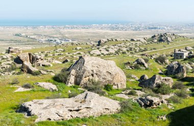Gobustan, Azerbaycan 'ın Kichikdash bölgesindeki manzara, kaya yığınları ve Gobustan hapishanesi ve arka planda yerleşim.