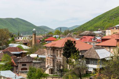 Sheki, Azerbaycan - 29 Nisan 2019. Azerbaycan 'ın Sheki kasabasının şehir merkezindeki tarihi bina ve camii manzarası.