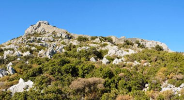 Türkiye 'nin Marmaris tatil beldesi yakınlarındaki Bozburun yarımadasındaki müstahkem kalenin kalıntılarıyla kaplı Rocky manzarası.