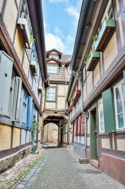 Quedlinburg, Almanya - 19 Haziran 2016. Almanya 'nın Quedlinburg ortaçağ kasabasında yarı keresteli binaları olan dar bir sokak..