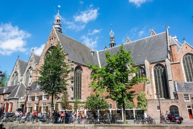 Amsterdam, Hollanda - 22 Haziran 2016. Amsterdam 'daki Oude Kirk kilisesinin insan ve bisikletli dış görünüşü. Oude Kirk, Amsterdam 'daki en eski bina ve en eski kilise, 1213 yılında kurulmuş ve 1306 yılında piskopos tarafından kutsanmıştır. 