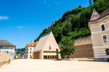 Vaduz, Liechtenstein - 28 Haziran 2016. Vaduz 'daki Peter-Kaiser-Platz meydanı ve Stadtle caddesinin manzarası, Landtag parlamento binası, hükümet binası ve arka plandaki kale.