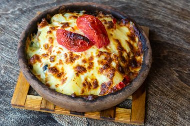 Gürcü usulü ojakhuri yemeği ve suluguni peyniri ve domatesle kaplı kızarmış patates..