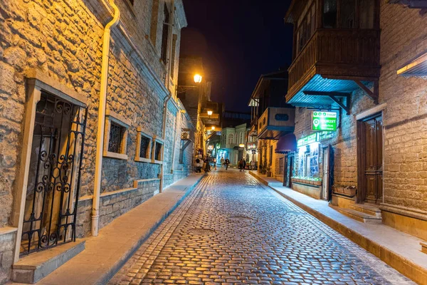 Bakü, Azerbaycan - 26 Nisan 2019. Azerbaycan 'ın Bakü kentindeki Icherisheher' in sokak manzarası. Geceleri ticari mülkleri ve insanları var..