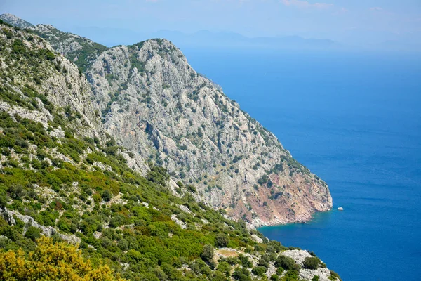 トルコのMarmarisリゾートタウンの近くにあるBozburun半島のAmeliyaビーチを隠す崖の方をご覧ください アメリヤ ビーチはロードス島への違法人身売買で有名である — ストック写真