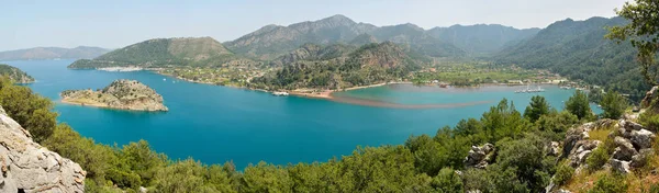 Türkiye 'nin Marmaris tatil beldesi yakınlarındaki Bozburun yarımadasında Orhaniye köyü ve Kizkumu plajı ile Orhaniye Körfezi üzerindeki panoramik manzara.
