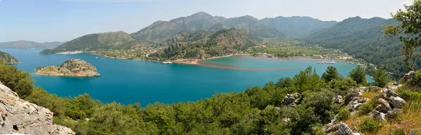 Türkiye 'nin Marmaris tatil beldesi yakınlarındaki Bozburun yarımadasında Orhaniye köyü ve Kizkumu plajı ile Orhaniye Körfezi üzerindeki panoramik manzara.