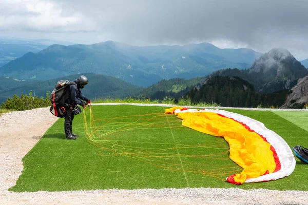 Fussen, Almanya yakınlarındaki dağlık alanda tanımlanamayan bir paraglider kalkışa hazırlanıyor..