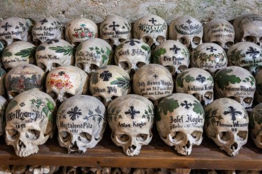 Hallstatt, Avusturya - 9 Temmuz 2016. Hallstatt 'taki Aziz Michael Şapeli' nde Beinhaus mezarlığında sıralanmış kafatasları. Küçük bir kilise 1200 'den fazla kafatasıyla dolu. Kafatası resmi özellikle 19. yüzyılda yapılmış ve ait.