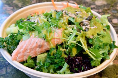 Bir kase füme somon, siyah pirinç, avokado, lahana, zencefil turşusu havuç, salatalık, taze İsveç maydanozu, balkabağı ve ayçekirdeği, fesleğen ve limon soslu..