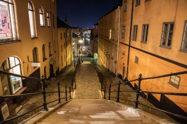 Stockholm, İsveç - 17 Kasım 2018. Stockholm 'ün Sodermalm semtinde tarihi binalar ve merdivenlerle sokak manzarası.