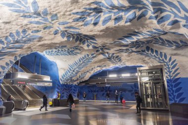 Stockholm, İsveç - 19 Kasım 2018. Stockholm metrosunun T-Centralen metro istasyonunun iç manzarası, insanlar, bilgi panoları ve yürüyen merdivenler..