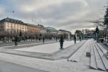 Stockholm, İsveç - 22 Kasım 2018. Stockholm 'deki Kungstradgarden parkı çevresindeki binalar, bitki örtüsü ve insanlarla dolu..