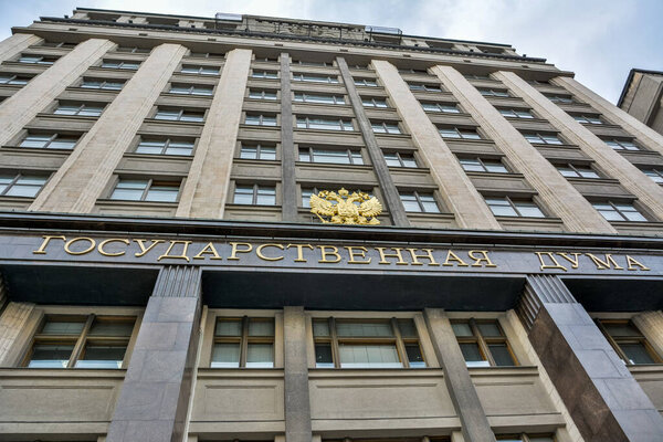 Moscow, Russia - June 8, 2017. Facade of the State Duma building at 1 Okhotny Ryad Street in Moscow. View with the Russian coat of arms and State Duma name in Russian.The State Duma is the lower house of the Federal Assembly of Russia.