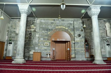Trabzon, Turkey - September 6, 2018. Interior view of Aya Sofya mosque in Trabzon, Turkey, with two columns, furniture and Arabic inscriptions. 