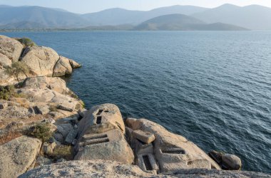Landscape around Lake Bafa in Turkey, with ancient tombs near the water.