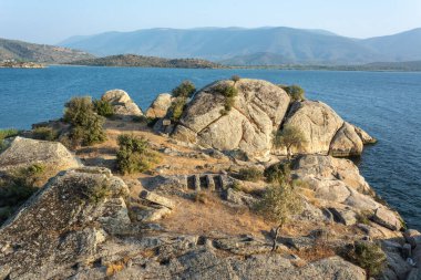 Landscape around Lake Bafa in Turkey, with ancient tombs near the water.