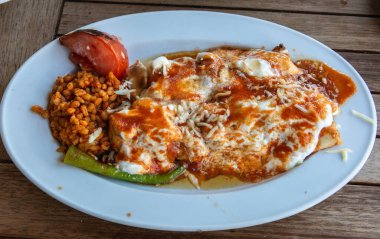 Turkish sarma beyti kebap with bulgur cereals and covered with yogurt.