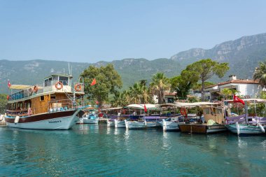 Akyaka, Mugla, Turkey - July 30, 2016. Boats on Azmak stream in Akyaka village in Mugla province of Turkey, with Sakar mountains in the background.