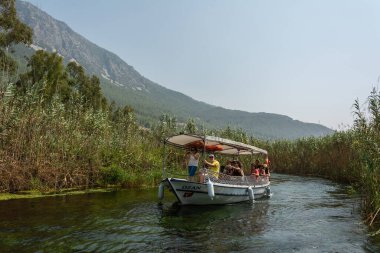 Akyaka, Mugla, Turkey - July 30, 2016. Tour boat on Azmak stream in Akyaka village in Mugla province of Turkey, with people.