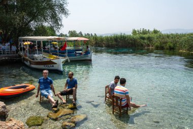 Akyaka, Mugla, Turkey - July 30, 2016. Azmak stream in Akyaka village in Mugla province of Turkey, with people and boats.