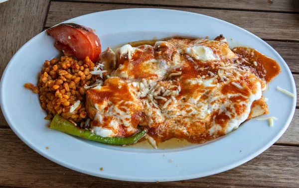 Turkish sarma beyti kebap with bulgur cereals and covered with yogurt.