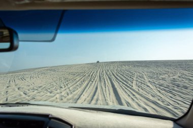 View out of a car windshield on a dune driving tour in Khor Al Adaid desert in Qatar.