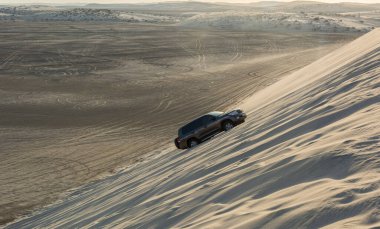 Khor Al Adaid, Qatar - November 5, 2016. 4WD vehicle driving up a sand dune in Khor Al Adaid desert in Qatar. 