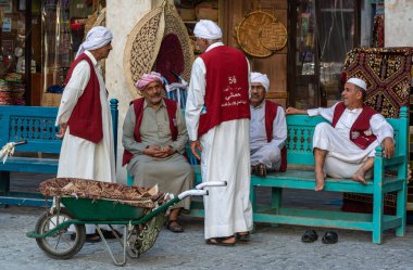 Doha, Qatar - November 9, 2016. Alhmalah porters in numbered maroon waistcoats enjoying free time in Doha. 
