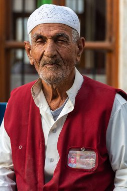 Doha, Qatar - November 9, 2016. Portrait of alhmalah porter in numbered maroon waistcoat in Doha.