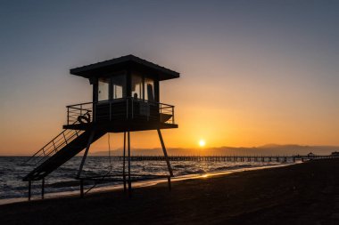 Lifeguard tower on Mediterranean beach in Belek resort town of Antalya province in Turkey, at sunset.
