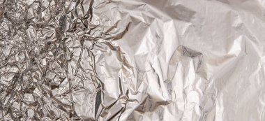 Gümüş renkli, buruşuk folyo desenli arka plan. Üst görünüm