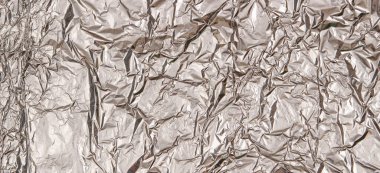 Gümüş renkli, buruşuk folyo desenli arka plan. Üst görünüm
