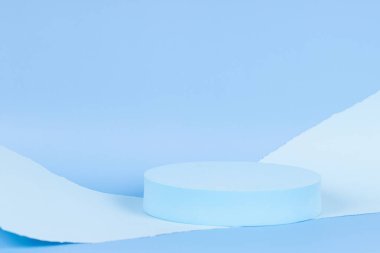 Ürün sunumu için boş yuvarlak podyum platformu ve açık mavi arkaplanda yırtık kağıt kenarlı soyut monokrom kompozisyonu. Ön görünüm