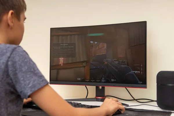 Vilnius, Lithuania - October 09, 2021: Teenager playing video game Valorant on computer at home. Valorant is a free-to-play first-person hero shooter developed and published by Riot Games — Stock Photo, Image