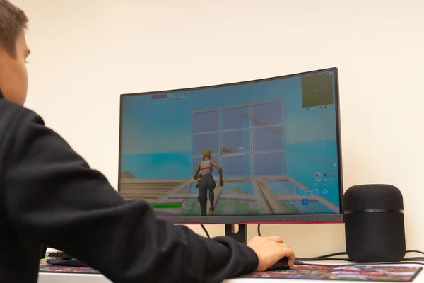 Vilnius, Lithuania - October 09, 2021: Teenager playing Fortnite video game on PC computer at home. Fortnite is survival online video game developed by Epic Games — Stock Photo, Image