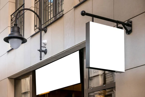 Gúnyolódj! Üres fehér téglalap alakú tábla a falon és a bejárat felett a szabadban. Üzlet, áruház, kávézó, étterem felirata — Stock Fotó