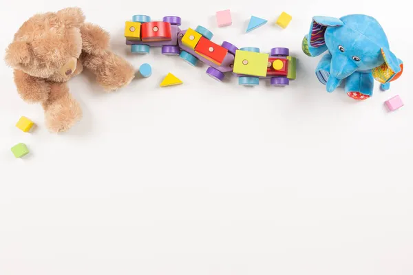 Criança crianças brinquedos quadro. Brinquedos educativos coloridos de madeira e fofos para crianças dispostas em fundo branco. Vista superior, flat lay — Fotografia de Stock