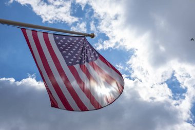 Mavi gökyüzünde sallanan Amerika Birleşik Devletleri bayrağı. Amerikan bayrağına alçak görünüm