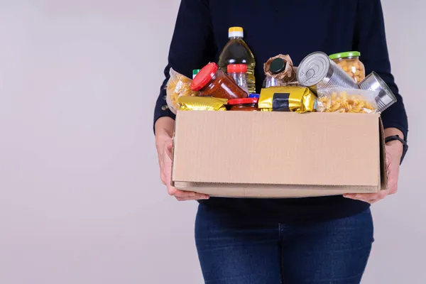 Kvinnan frivilliga händer hålla mat donationer box med livsmedel livsmedel produkter — Stockfoto